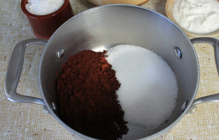 1. Этап. Шоколадный чизкейк в домашних условиях: Готовим шоколадную глазурь. В кастрюлю насыпаем какао-порошок и 0,5 стакана сахара.