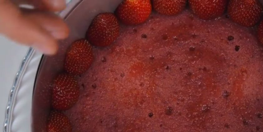 1. Этап. Нежный торт Мечта: 8. На блюдо установите корж, пропитайте его клубничным сиропом. Установите вокруг коржа кольцо, выстелите изнутри ацетатной пленкой и сомкните кольцо. По периметру выложите половинки клубники срезом к форме.