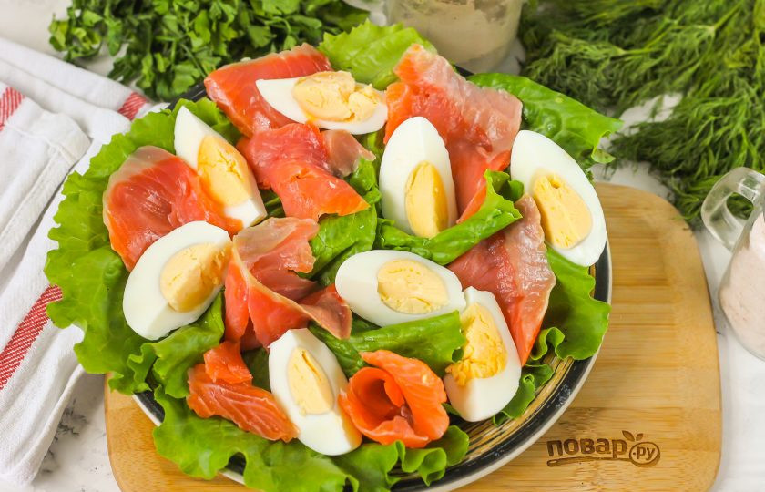 1. Этап. Салат с красной рыбой и грейпфрутом: Слабосоленую нарезку красной рыбы нарежьте ломтиками, выложите между яичными четвертинками.