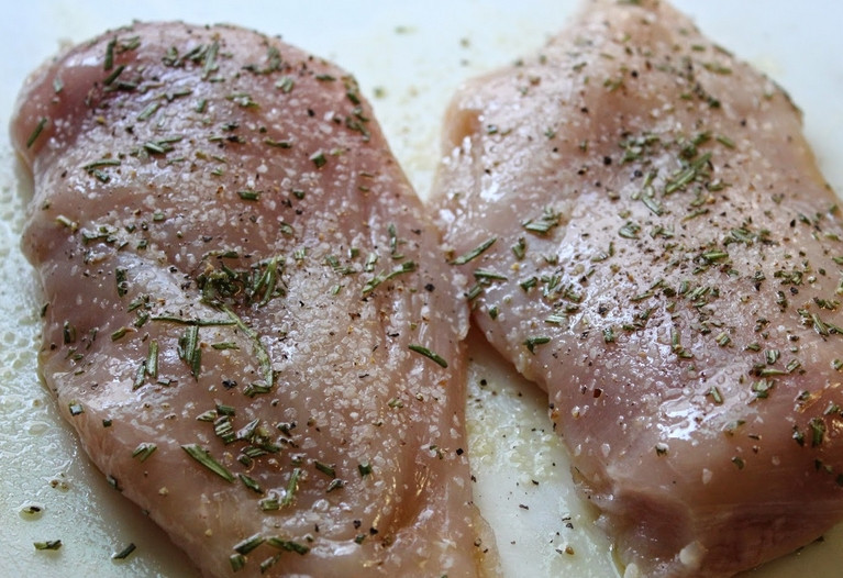 1. Этап. Cалат из кукурузы и курицы: Куриные грудки слегка отбейте. Смажьте оливковым маслом и присыпьте специями ос всех сторон.