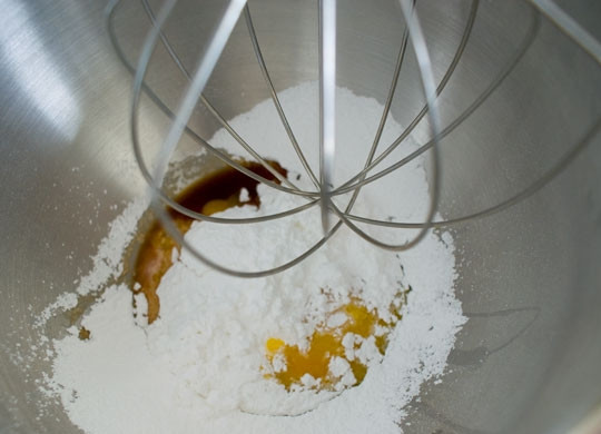 1. Этап. Бисквитный торт с шоколадом: 2. Разогрейте духовку до 200 градусов. К желткам добавьте сахарную пудру и ванильную эссенцию (в рецепт приготовления бисквитного торта с шоколадом вы можете также использовать цитрусовую цедру для аромата).