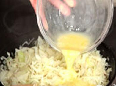 1. Этап. Быстрый капустный пирог: 2. Готовим начинку. Мелкой соломкой рубим капусту, солим и разминаем руками. Кладем семена тмина и мелко нарезанную зелень. Сковороду ставим на плиту и кладем приготовленное для жарки сливочное масло. Когда расплавится масло, кладем капусту, и на среднем огне тушим до готовности, чтобы капуста не подгорела, доливаем по немного воды. Взбитыми яйцами поливаем капусту, и хорошо размешиваем.