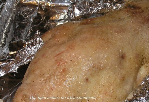 1. Этап. Рождественский гусь с фруктами и картофелем: Крылышки и ножки гуся оберните фольгой, чтобы они не подгорели. Уложите гуся грудкой вниз на большой противень и отправьте в разогретую до 220°С духовку.