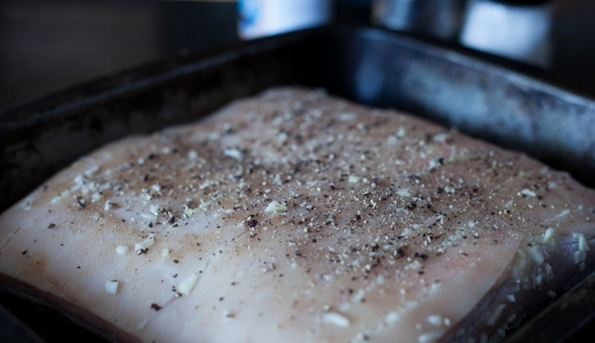 1. Этап. Свинина запеченная с чесноком: Спустя несколько часов достаньте свинину из фольги, положите на форму для запекания, сверху посыпьте черным перцем и слегка сбрызните маслом (чтобы шкурка не пригорела). Да, класть нужно шкуркой вверх.