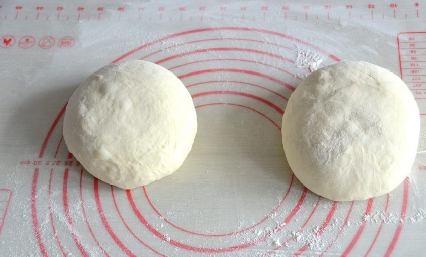1. Этап. Лепешки Оби-нон: Присыпьте мукой рабочую поверхность стола, выложите тесто, разделите на 2 части. Подкатайте тесто в шар, накройте пищевой пленкой, оставьте для подъема на 30 минут.