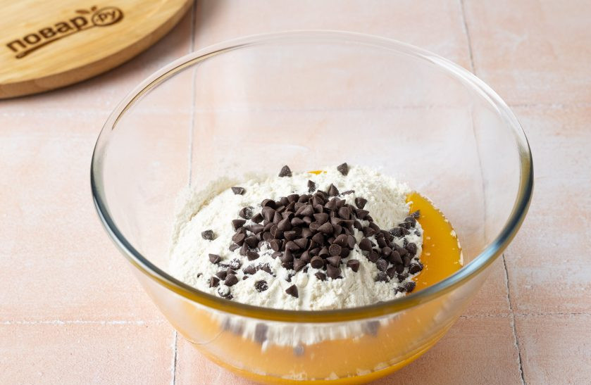 1. Этап. Печенье без яиц: Просейте муку в миску, добавьте разрыхлитель, щепотку соли и шоколадные капли.