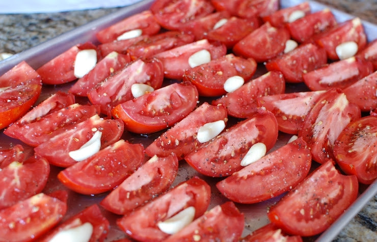 1. Этап. Помидоры, сушеные в духовке: Выкладываем на помидоры зубчики чеснока.