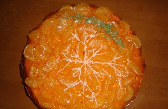 1. Этап. Мандариновый чизкейк: 8. Сметаной рисую украшения в виде снежинки, а небольшую часть смешиваю с пищевым красителем (зеленого цвета), рисую веточку.