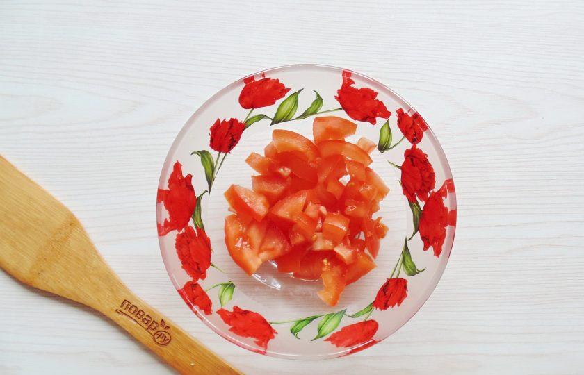 1. Этап. Салат Лора с баклажанами: Помидоры вымойте и нарежьте небольшими кусочками. Переложите в салатник.