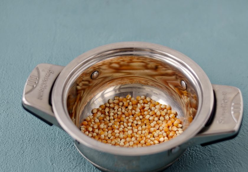 1. Этап. Соленый попкорн: Снизьте температуру, добавьте кукурузные зерна, быстро перемешайте и закройте крышкой. Кукурузные зерна будут взрываться примерно 5 минут.