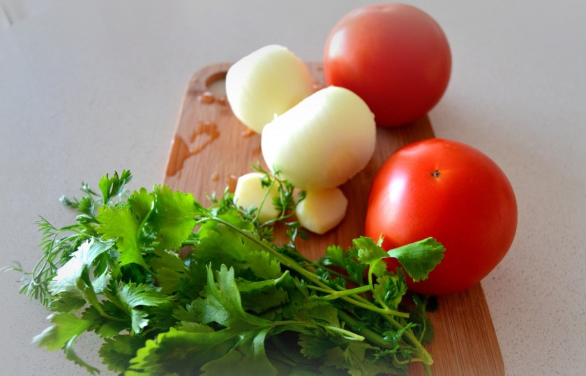 1. Этап. Жареные осьминоги: Отправляем осьминога варится - около часа, воду не солим. Тем временем делаем салат. Порежьте помидоры, измельчите чеснок, порубите зелень и лук.