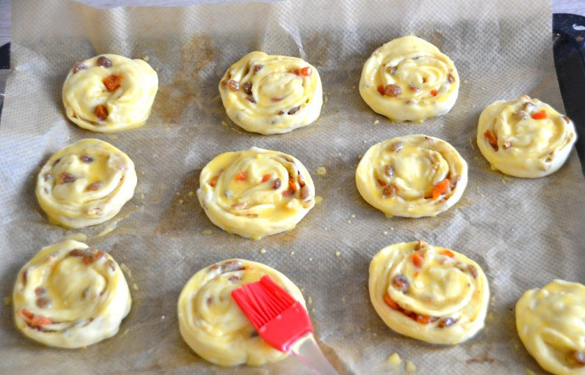 1. Этап. Канадские булочки: Нарежьте рулет из теста на кусочки примерно по 3 см. толщиной, выложите их на лист для выпечки. Смажьте смесью из яичного желтка и 2 ст. ложек молока. Поставьте на расстойку на 15-20 минут. В это время разогрейте духовку до 180 градусов.