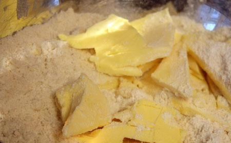 1. Этап. Миндальный пирог: 1. Замочите миндаль в горячей воде на пару минут. Снимите с него шкурку. Подсушите на горячей сковородке. Измельчите миндаль до мелкой крошки. Всыпьте в него просеянную муку, сахар, нарезанное холодное сливочное масло. Все ингредиенты тщательно перебейте ножом.