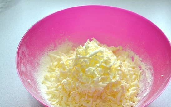 1. Этап. Пирог с фетой и шпинатом: Приготовьте тесто. В глубокую миску просейте муку и натрите на терке холодное сливочное масло.