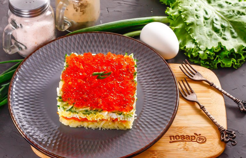 1. Этап. Слоеный салат с красной икрой: На огуречный слой выложите красную икру. Украсьте ее мелко нарезанным зеленым луком и аккуратно удалите форму.