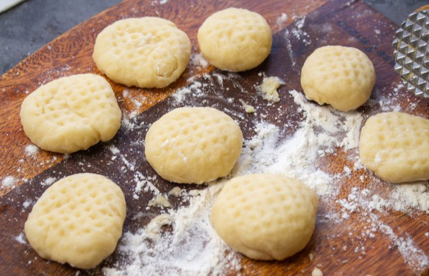 1. Этап. Печенье на сметане в сковороде: Кусочки теста скатайте в шарики и при помощи молоточка для отбивания мяса нанесите узор.