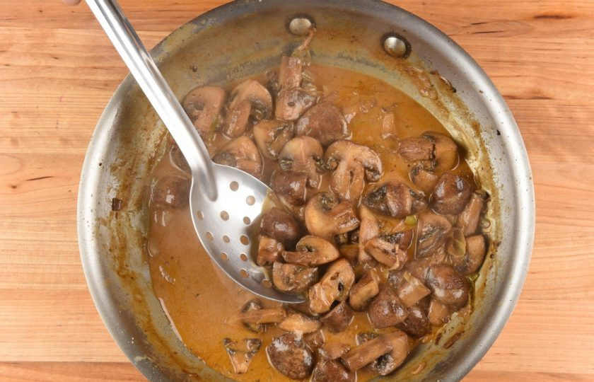 1. Этап. Стейк Марсала: 5. К шампиньонам добавьте оставшийся лук и вино. Тушите всё 2 минуты. Следом влейте воду, молоко, соус и образовавшийся мясной сок. Готовьте ещё 3 минуты, помешивая.