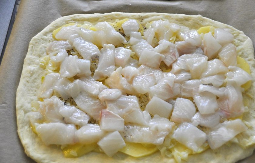 1. Этап. Пирог с зубаткой: На лук выложите кусочки рыбы, рыбу тоже слегка подсолите.