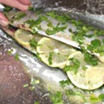 1. Этап. Скумбрия с травами и лимоном, запеченная в фольге: 2. Вилкой разомнем сливочное масло, добавим каперсы, мелко нарезанную зелень базилика и петрушки, лимонный сок и соль. Внутри и снаружи каждой скумбрии смазываем получившейся смесью. Внутрь брюшка каждой рыбы кладем тонко нарезанные лимоны и измельченную зелень.