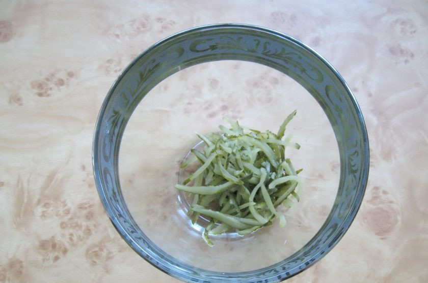 1. Этап. Салат с курицей и лапшой из омлета: Маринованные огурцы нарежьте соломкой и выложите в салатник.