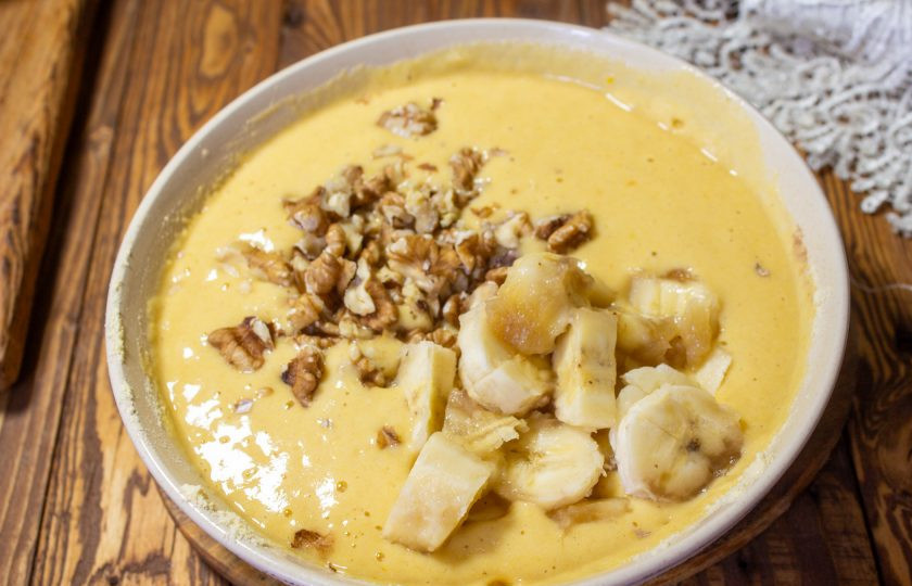 1. Этап. Пирог с бананом на кукурузной муке: Добавьте рубленые грецкие орехи и 1 банан нарезанный на кусочки. Перемешайте аккуратно тесто.