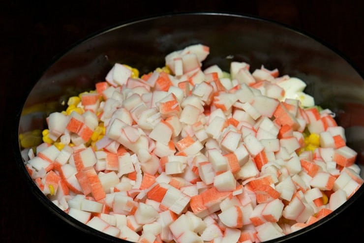 1. Этап. Салат с кукурузой и крабовыми палочками: Затем добавьте кукурузу и нарезанные крабовые палочки.