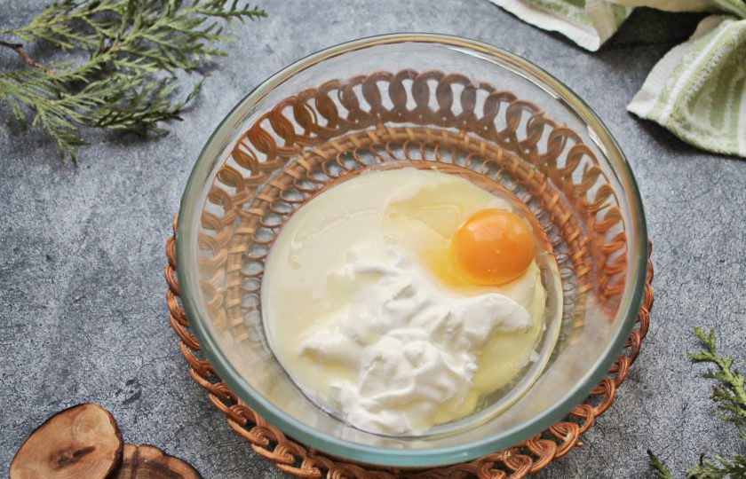 1. Этап. Кукурузные кексы с цукатами: В миску выложите сметану, разбейте яйцо и сгущенное молоко. Все хорошо перемешайте.