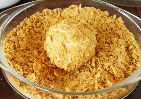 1. Этап. Жареные шарики из мороженого: 3. Аккуратно разверните пленку и обваляйте шарики в кукурузных хлопьях, слегка измельченных, со всех сторон.