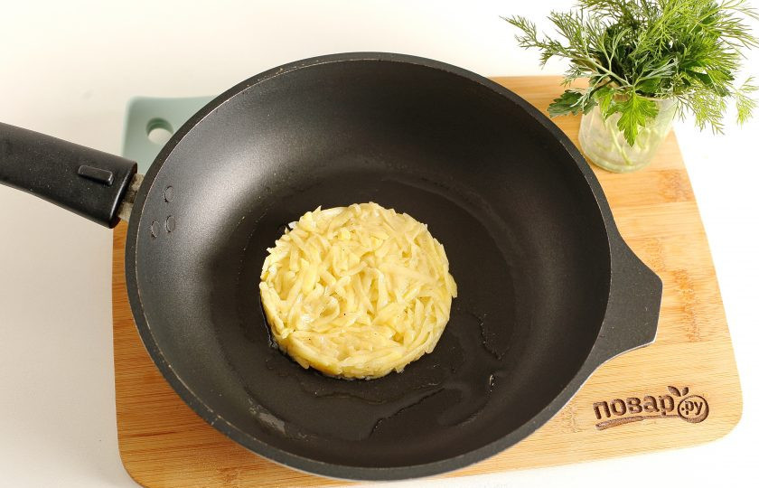 1. Этап. Драник-бургер: Картофель выкладывайте на раскаленную сковороду с маслом, сформировав круглую лепешку. Можно воспользоваться кулинарным кольцом.