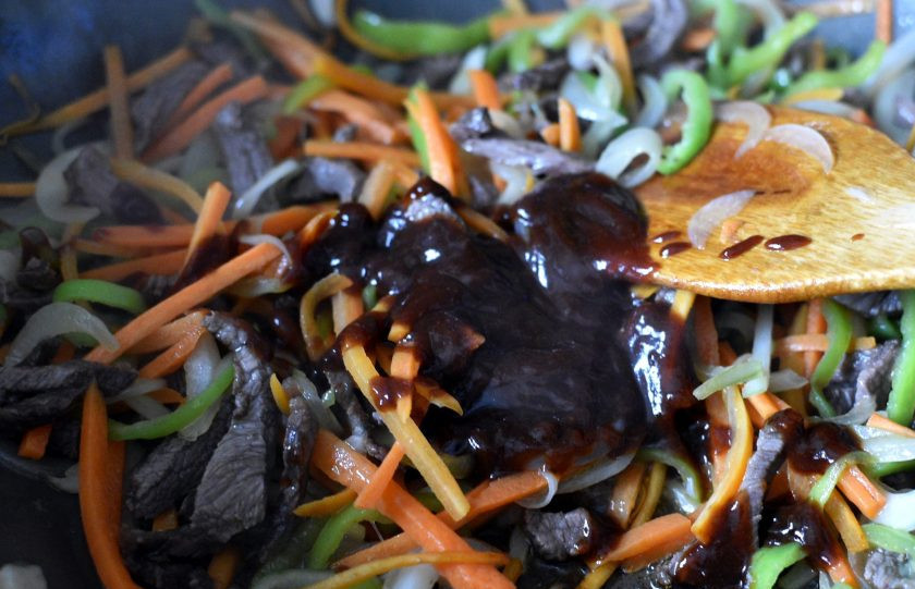 1. Этап. Маринованная говядина с овощами и зеленью: Влейте в вок соевый и устричный соус. Я добавила еще сладкого соуса хойсин, но это не обязательно. Пару раз активно перемешайте. Готовьте 2 минуты.