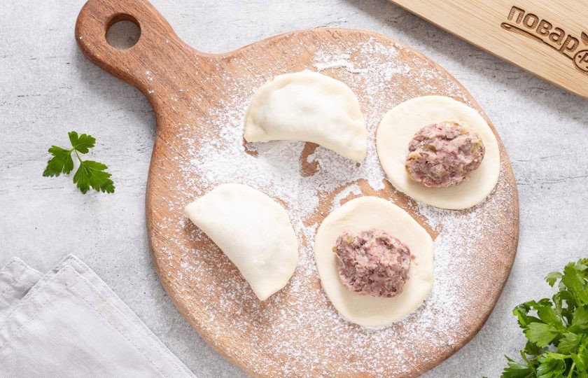 1. Этап. Вареники с фасолью: Раскатайте тесто в пласт толщиной 3-4 мм. С помощью стакана вырежьте кружки. В центр каждого выложите начинку.