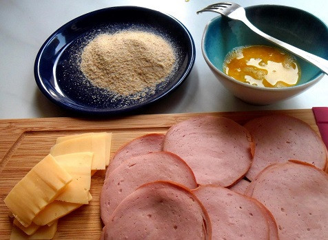 1. Этап. Колбаса в кляре с сыром: 1. Если вы не знаете, что приготовить на завтрак - побалуйте своих близких разнообразными закусками. Например, колбасой в кляре с сыром в домашних условиях. Нарежьте колбасу колечками толщиной 3 мм. Приготовьте миску с сухарями. В другой глубокой мисочке взбейте вилочкой яйцо. Тонкими пластинками нарежьте сыр.