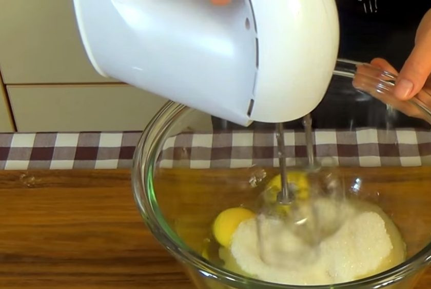 1. Этап. Простой пирог с абрикосами: 1. Яйца комнатной температуры взбейте с сахаром в течение двух минут. Добавьте жирную сметану и взбивайте еще полминуты. Просеянную муку смешайте с содой, солью и разрыхлителем.