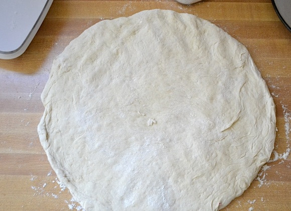 1. Этап. Пицца со сливочным соусом: 8. Переложите тесто на чистую, посыпанную мукой поверхность, сформируйте из теста круг.