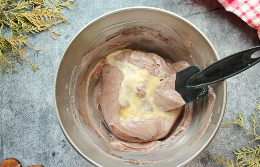 1. Этап. Шоколадный бисквит на белках: Влейте в тесто сливочное масло и аккуратно перемешайте.