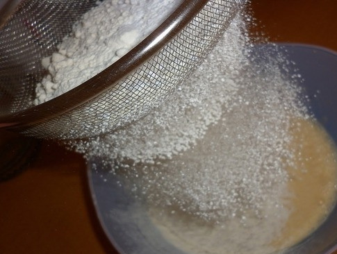 1. Этап. Торт Легкий: Просейте в получившуюся массу двести пятьдесят грамм муки. Вы можете просеять ее несколько раз перед тем, как ввести к другим ингредиентам, тогда корж получится намного пышнее. Добавьте к муке разрыхлитель и замесите жидкое тесто без комочков.