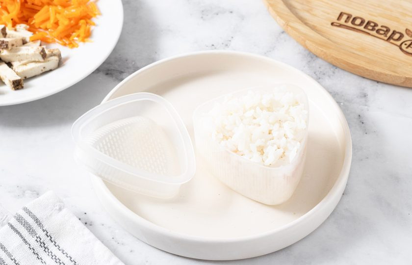 1. Этап. Онигири с корейской морковью: Накройте ее рисом. Придавите второй половинкой формочки. Затем извлеките из формы.