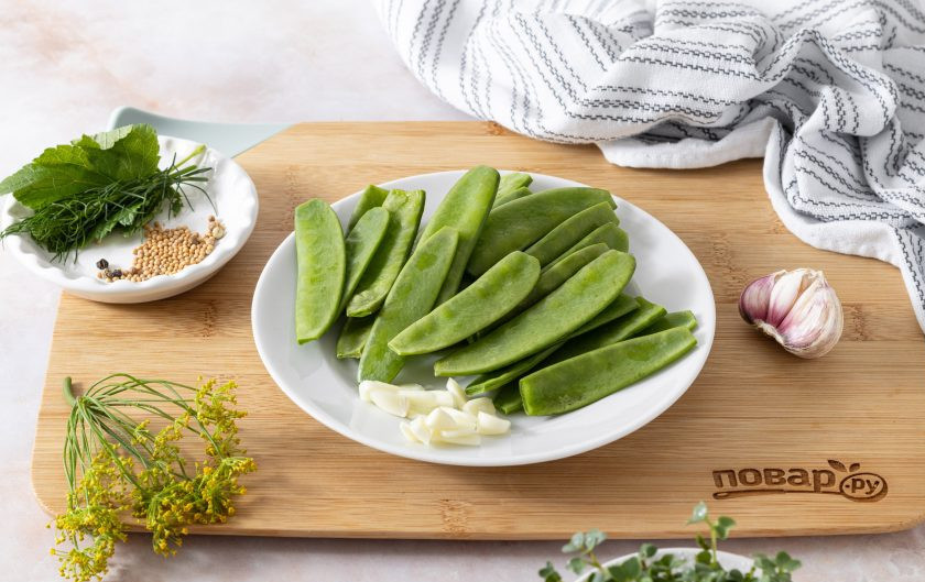 1. Этап. Маринованный зеленый горошек: Стручки гороха помойте, переберите и отрежьте сухие кончики. Чеснок очистите и нарежьте пластинами.