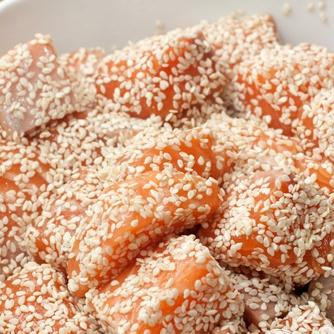 1. Этап. Лосось в кунжуте на подушке из цуккини: 2. Добавляем к кусочкам рыбы соевый соус, перемешиваем и всыпаем кунжут. Снова все хорошо перемешиваем, чтобы кунжут к рыбе прилипал равномерно.