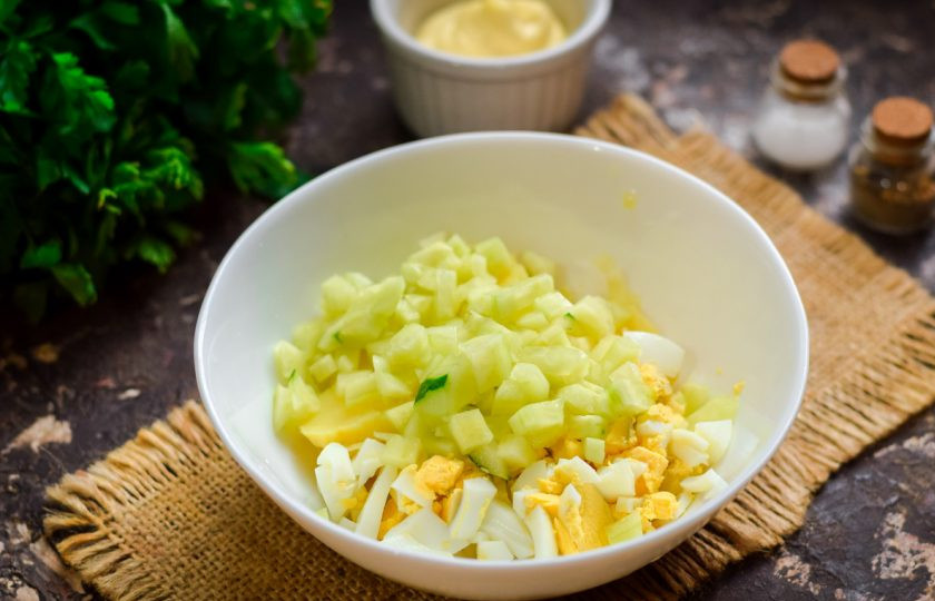 1. Этап. Оливье с горбушей: Свежие огурцы сполосните, по желанию почистите и нарежьте небольшими кубиками, добавьте в салат.