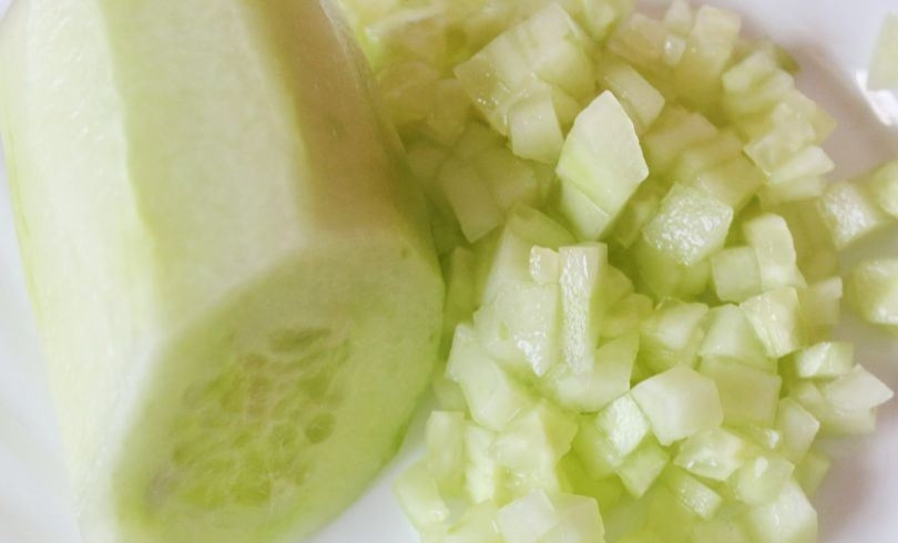 1. Этап. Соус к греческому салату: Разделите огурцы на две равные части. Одну из них измельчите ножом, порезав огурчики на мелкие кубики. Для соуса лучше использовать молодые плоды без крупных семечек.