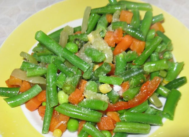 1. Этап. Кальмары, фаршированные овощами: 2. Для начала займитесь овощами: выложите их в глубокую мисочку, дайте им немного подтаять. Посолите, добавьте специи по вкусу. При желании можно их слегка поджарить на сковороде.