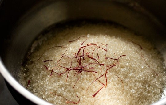 1. Этап. Джалеби индийские: 8. Для приготовления сладкого сиропа в небольшую кастрюльку отправьте сахар, шафран и воду. Поставьте на огонь.