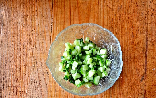 1. Этап. Салат с креветками и зеленым луком: На дно небольшого, желательно прозрачного, салатника выложите нарезанный мелкими кубиками огурчик.