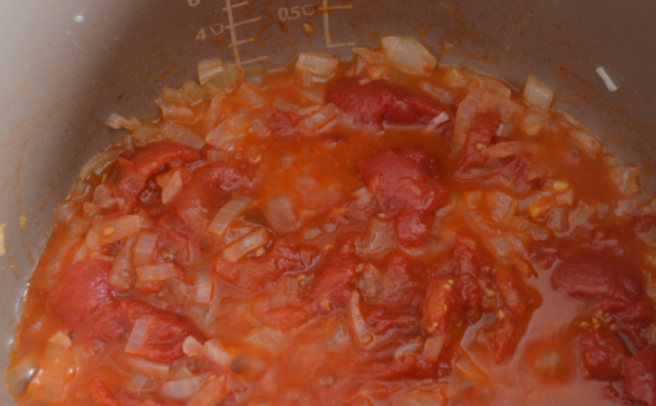 1. Этап. Кролик, тушеный в сметане в мультиварке: С томатов снимаем кожуру и слегка разминаем их ложкой. Добавляем томаты к луку, готовим вместе 3-4 минуты.