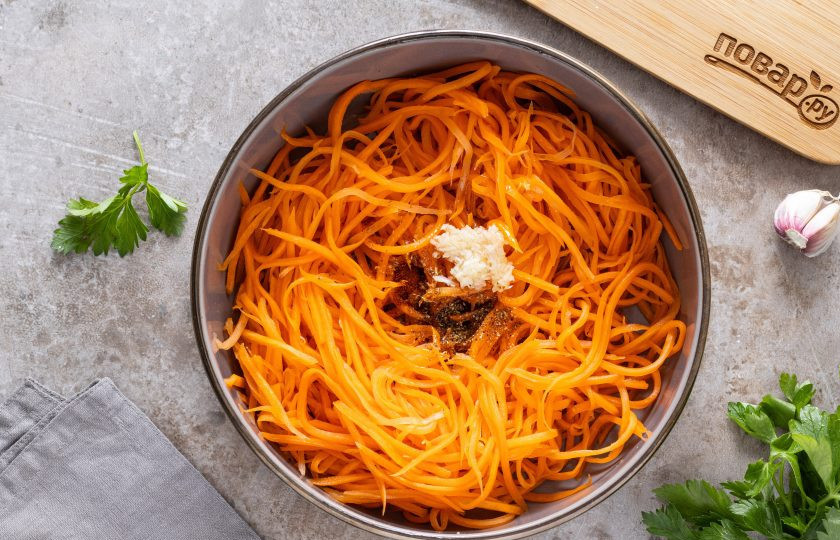 1. Этап. Морковь по-корейски Ча: В центр моркови выложите все специи и измельченный чеснок. Удалите лук из сковороды, а кипящим маслом полейте специи и чеснок в центре моркови.