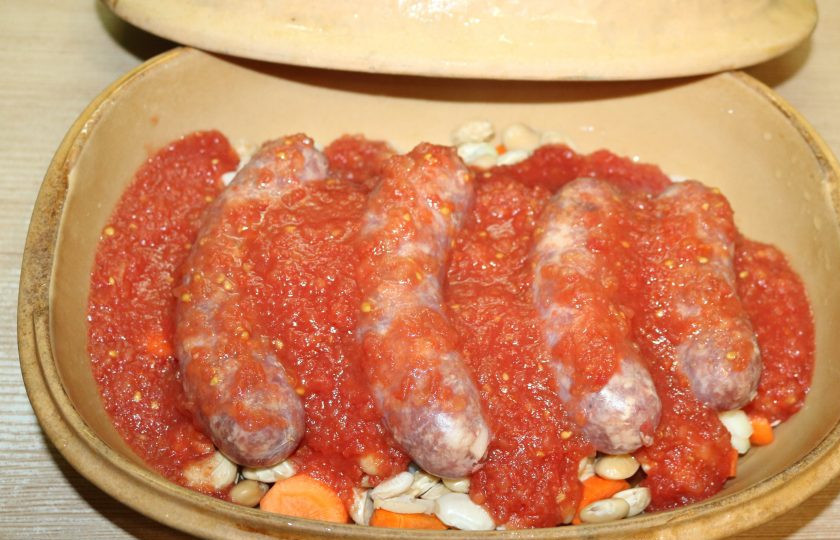 1. Этап. Фасоль с колбасками: Залейте водой и протёртыми помидорами. Посолите, поперчите.