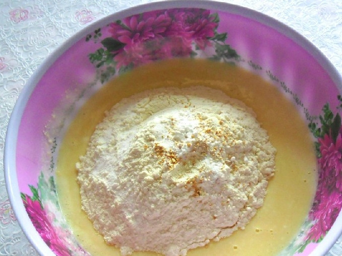 1. Этап. Пышные оладьи с творогом: Теперь можно смешать с творогом яйца с сахаром. Поместите все ингредиенты в одну ёмкость, перемешайте. Сюда же начинайте постепенно водить муку и вместе с ней добавьте соду и натёртую апельсиновую цедру. Хорошо вымешайте тесто ложкой или блендером, чтобы избавиться от мучных комочков.