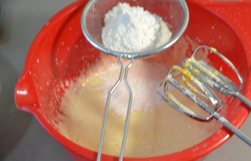 1. Этап. Мокрый бисквит: Небольшими порциями просейте муку к желткам, взбейте массу с мукой.