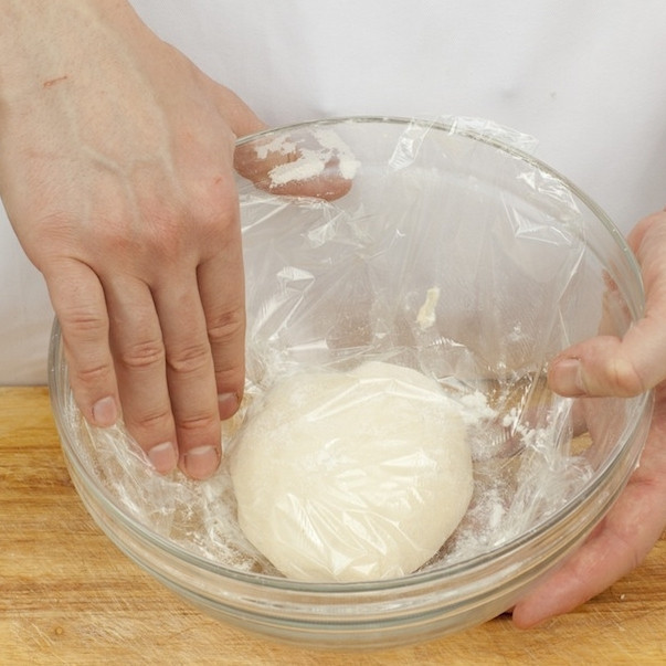 1. Этап. Пицца тонкая: Сперва приготовим тесто. Для этого смешаем молоко, теплую воду, соль и дрожжи. В получившуюся смесь вводим муку, хорошенько перемешиваем, добавляем оливковое масло. Тщательно вымешиваем тесто, затем накрываем пищевой пленкой и отправляем в теплое место на 40 минут.